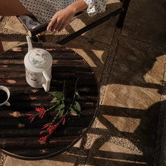Table basse Bosc Design au pied d'un fauteuil en bois, ambiance café du matin en Provence